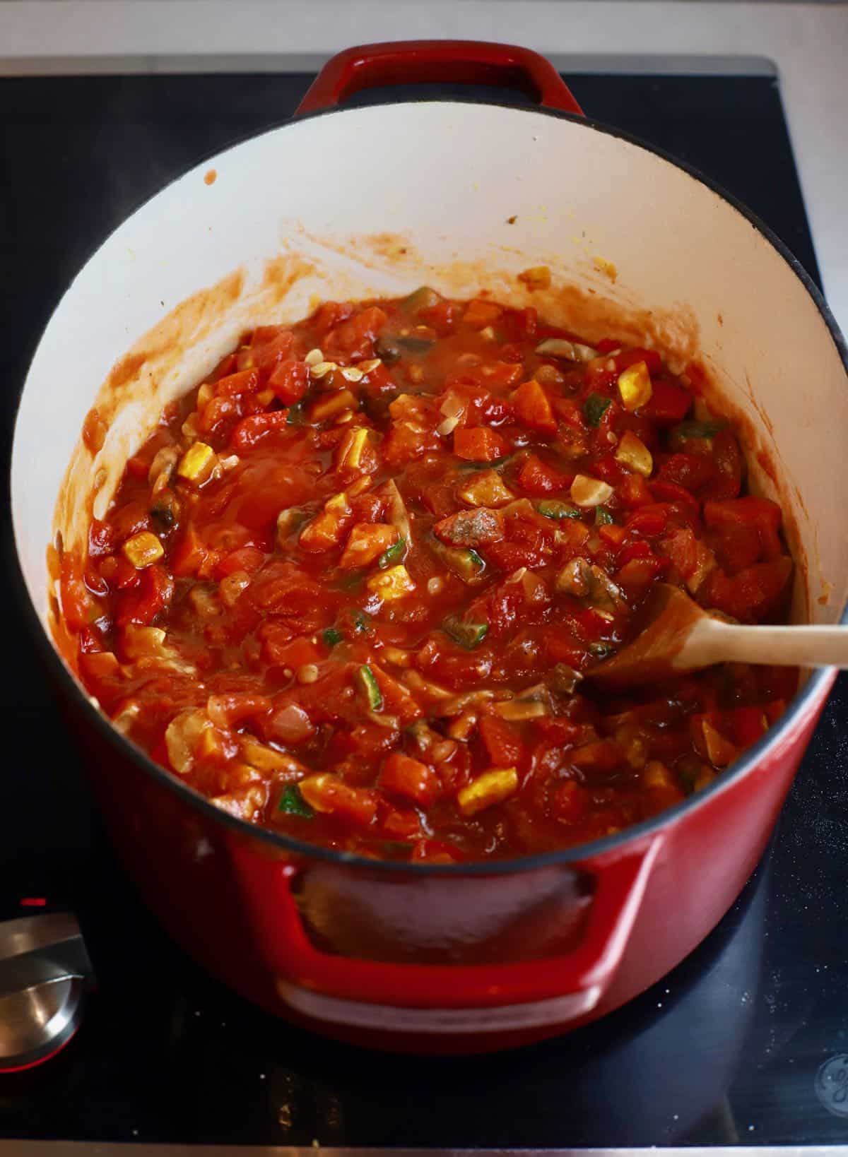 Tomato sauce and vegetables cooking in a dutch oven. 