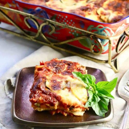 A brightly colored baking dish with lasagna and a slice of lasagna on a plate.