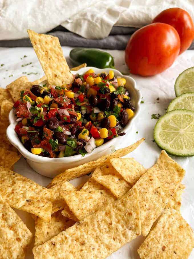 Black bean salsa in a dish next to tortilla chips.