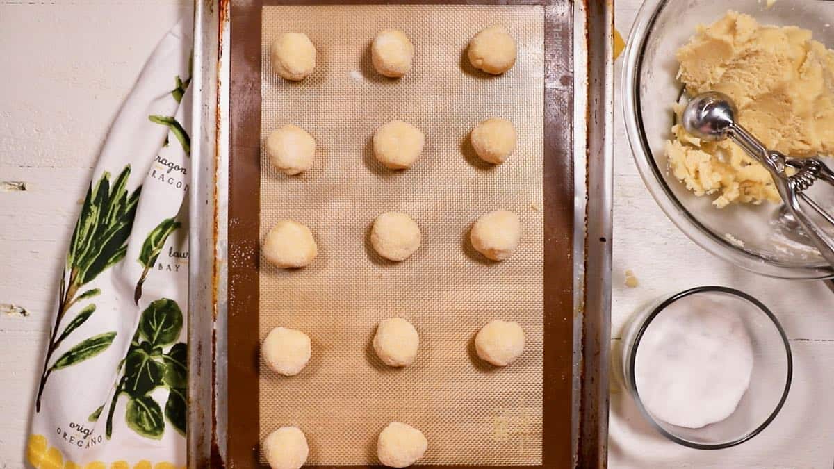 Balls of shortbread dough on a baking sheet. 