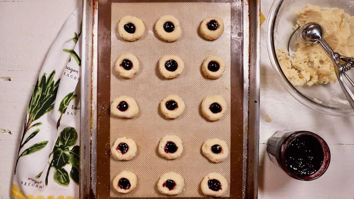 Thumbprint cookies filled with jam ready to bake. 