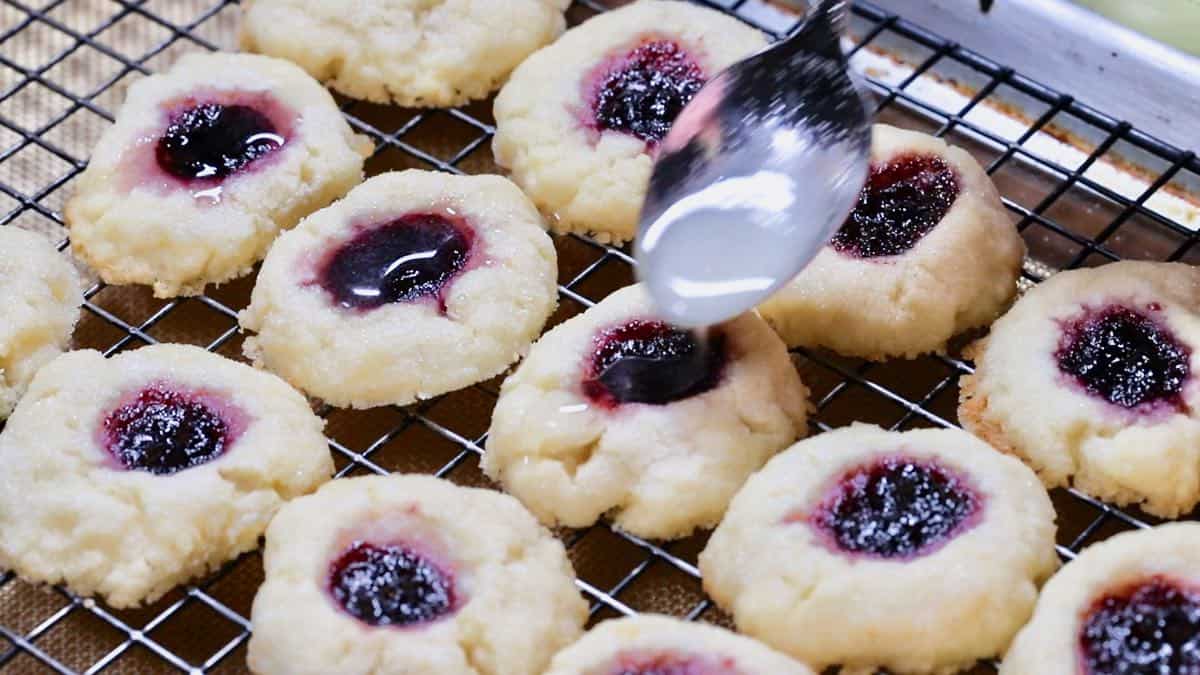 Spooning lemon glaze over cooled cookies. 