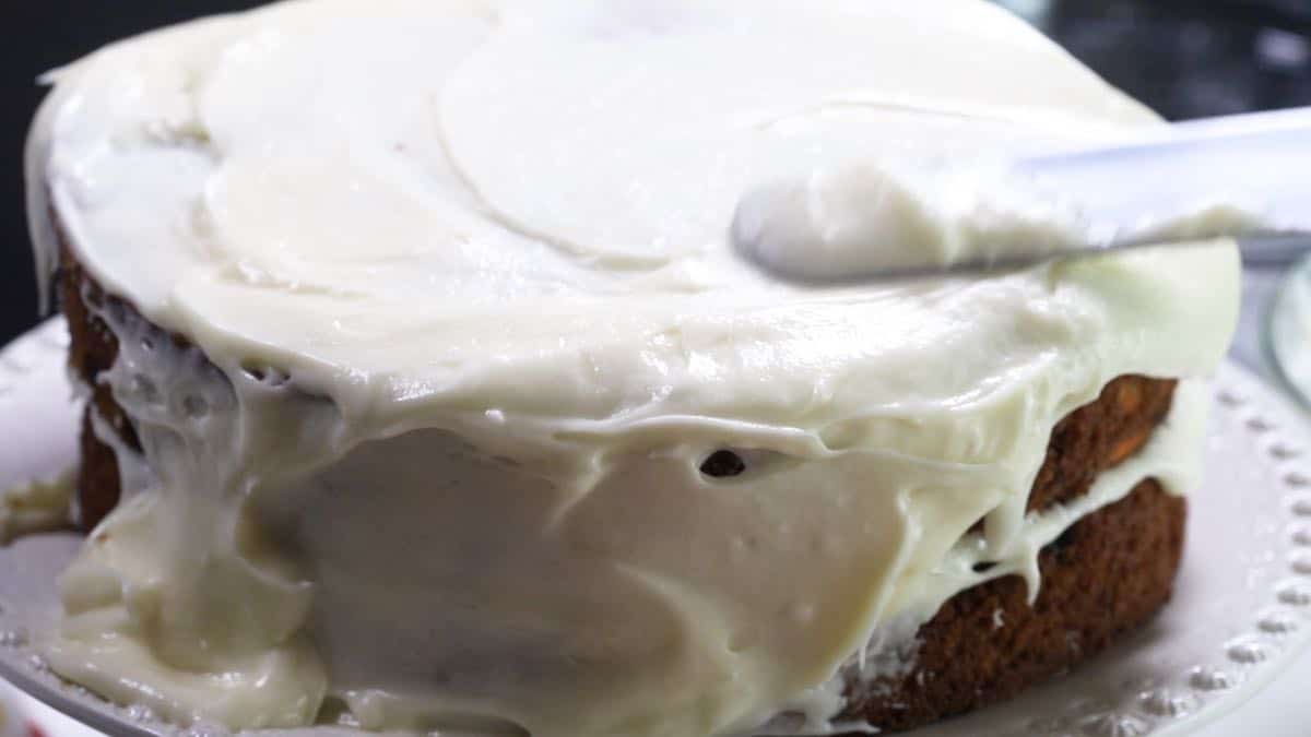 Icing a cake with cream cheese frosting. 