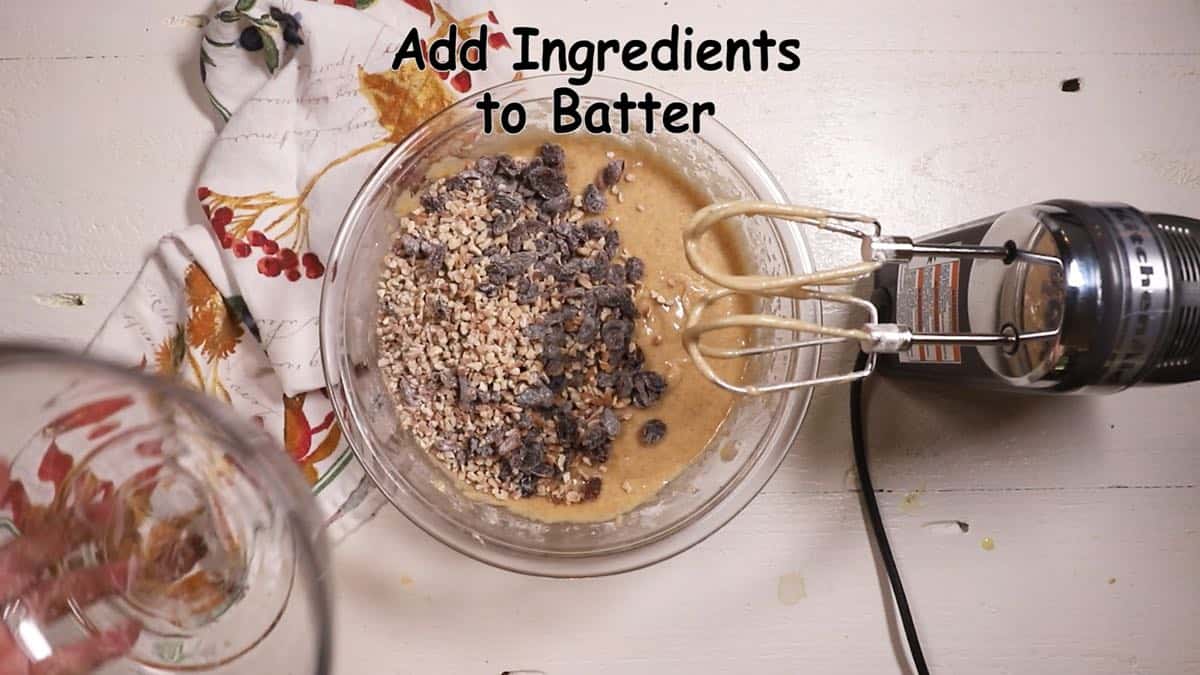 Adding raisins and pecans to cake batter. 