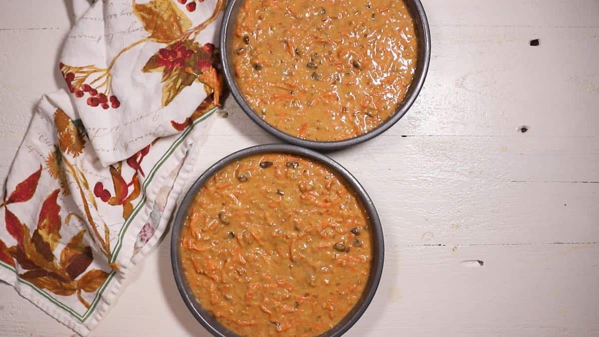 Two cake pans with carrot cake batter ready for the oven. 