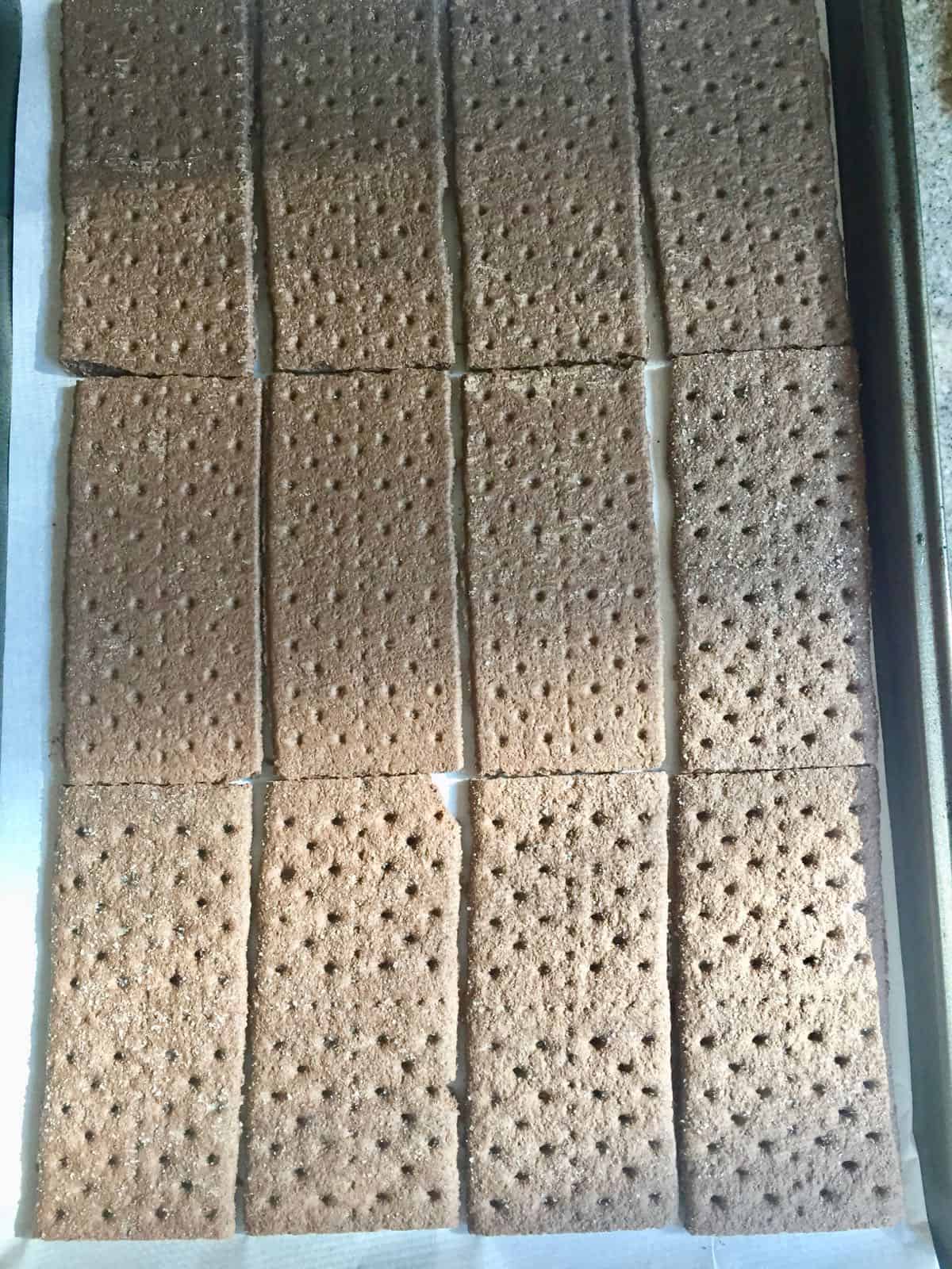 Chocolate graham crackers on a baking sheet. 