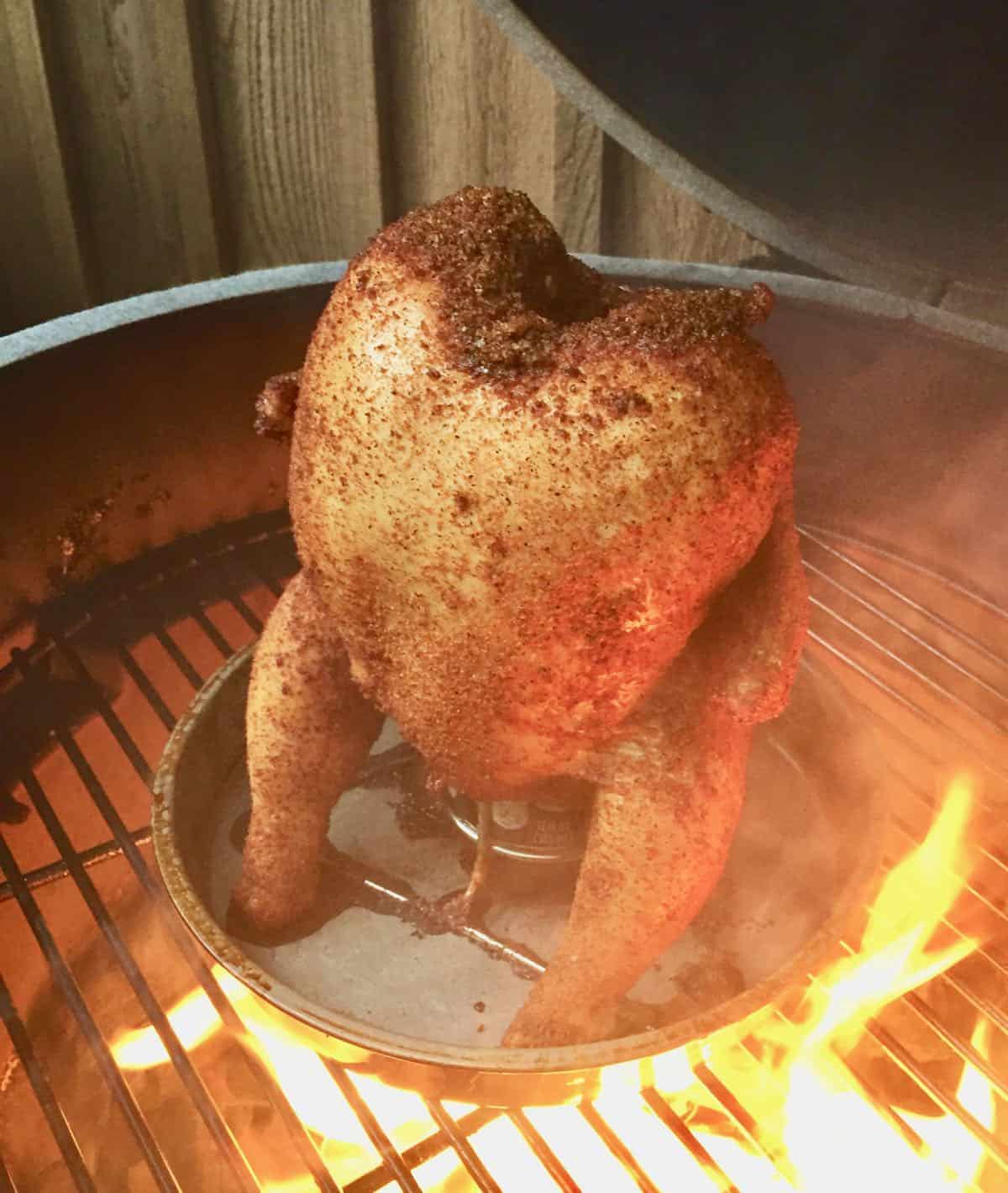 Flames from a grill with poultry cooking.