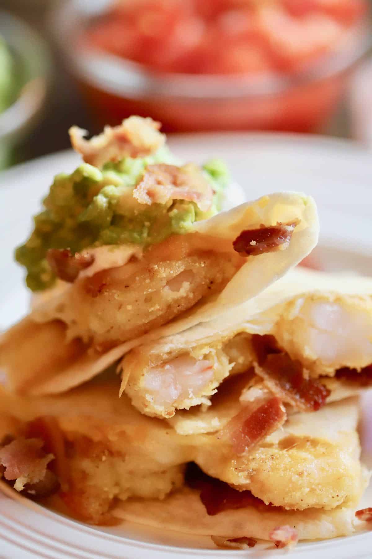 Shrimp quesadilla with bacon stacked on top of each other.