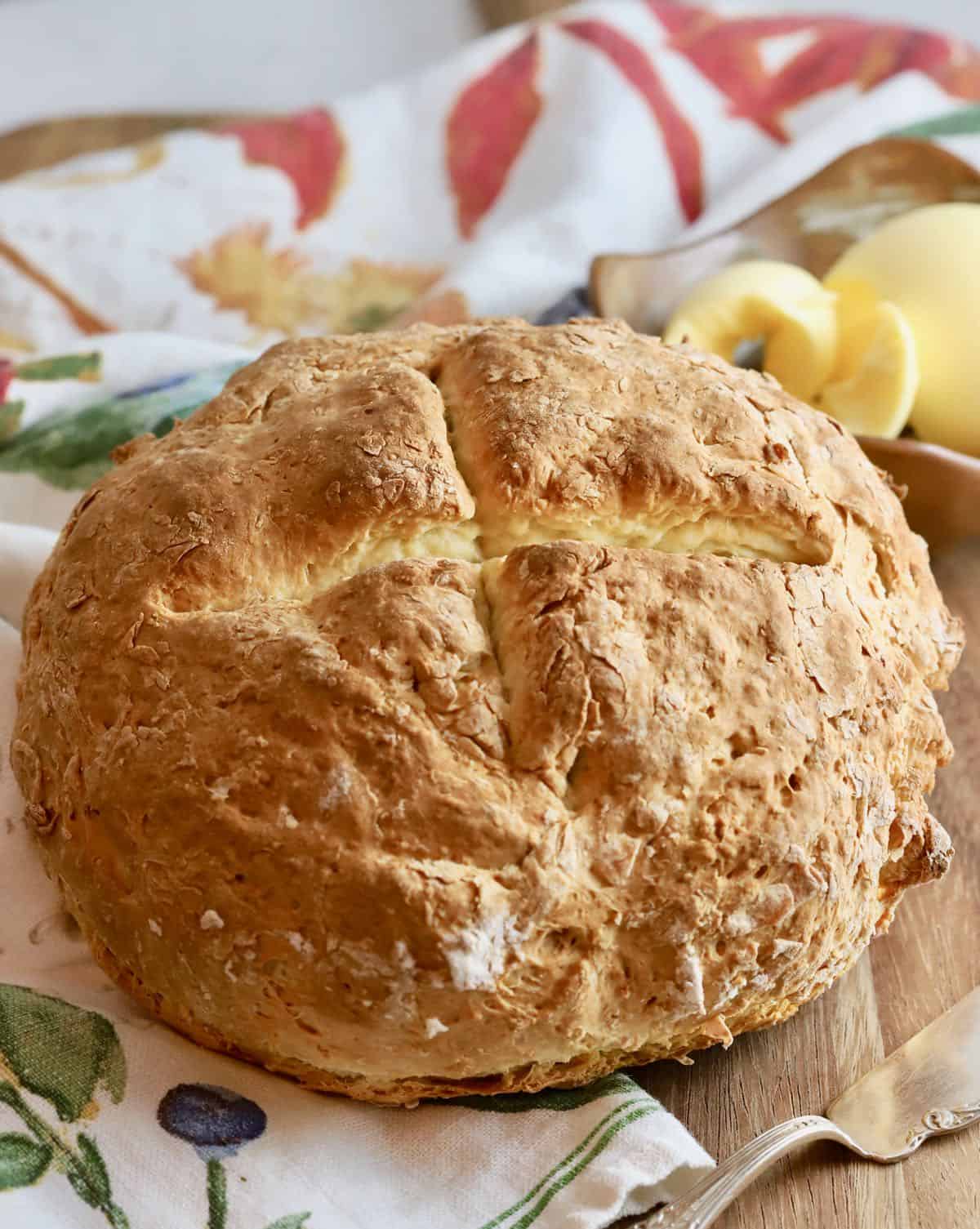 A loaf of soda bread on top of a kitchen towel.