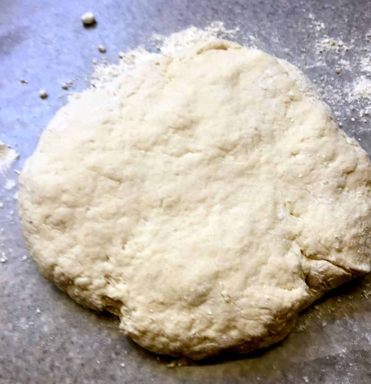 A round of bread dough on a baking sheet.