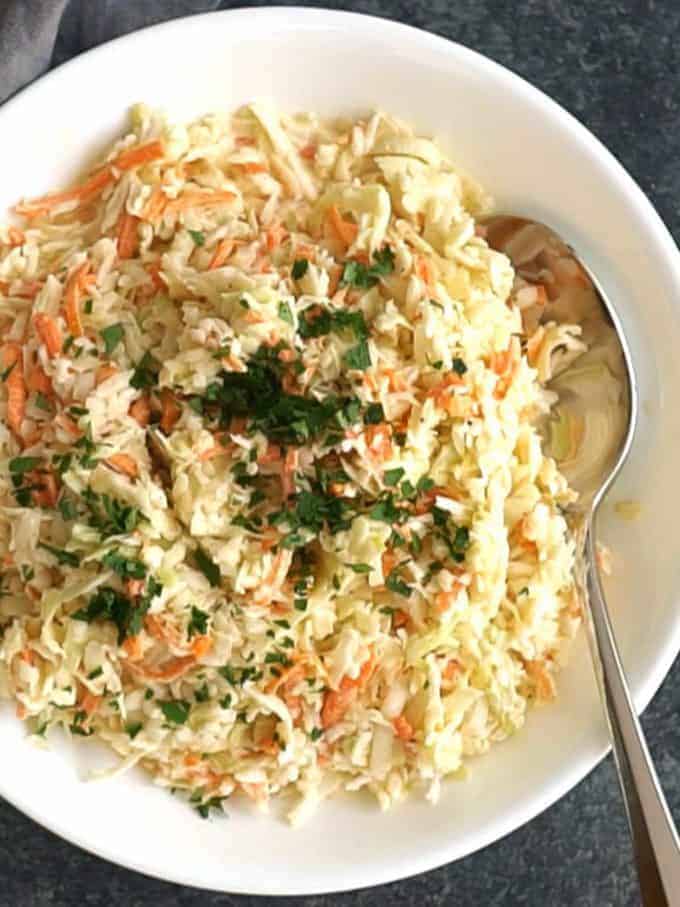 A large white bowl full of coleslaw.