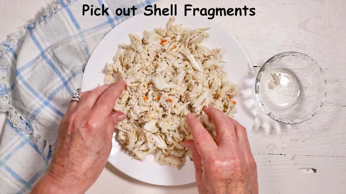 Picking over crab meat on a plate to remove any bits of shell.