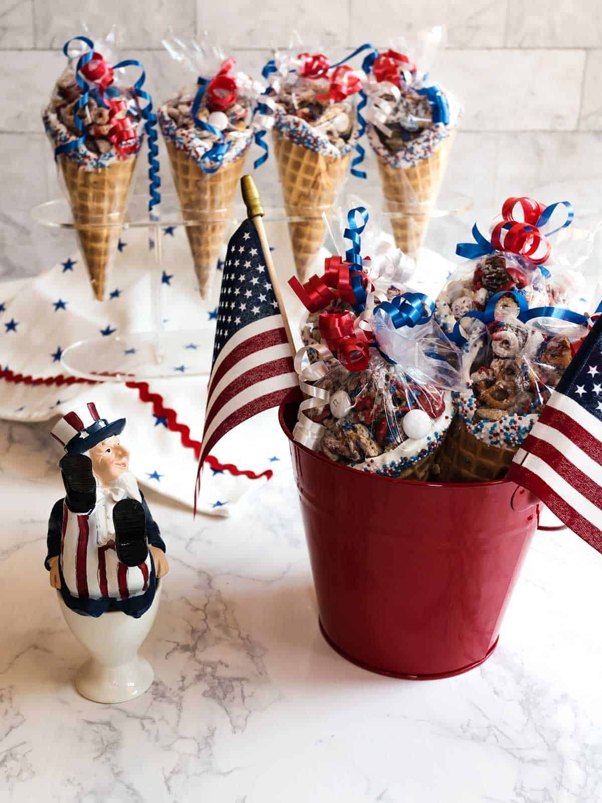 Ice cream waffle cones full of a red, white and blue snack mix.