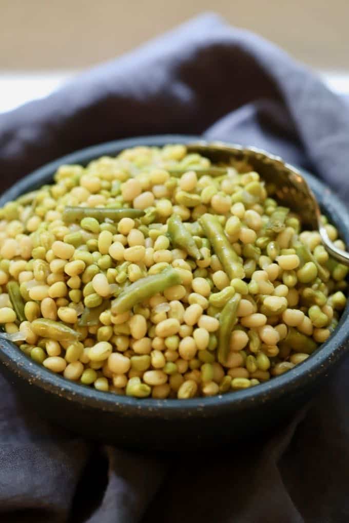 A bowl full of cooked field peas with snaps.