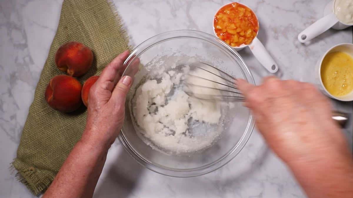 Mixing oil and sugar in a glass bowl. 