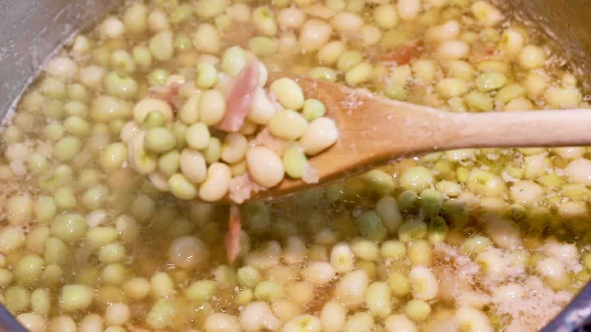 A wooden spoonful of peas. 