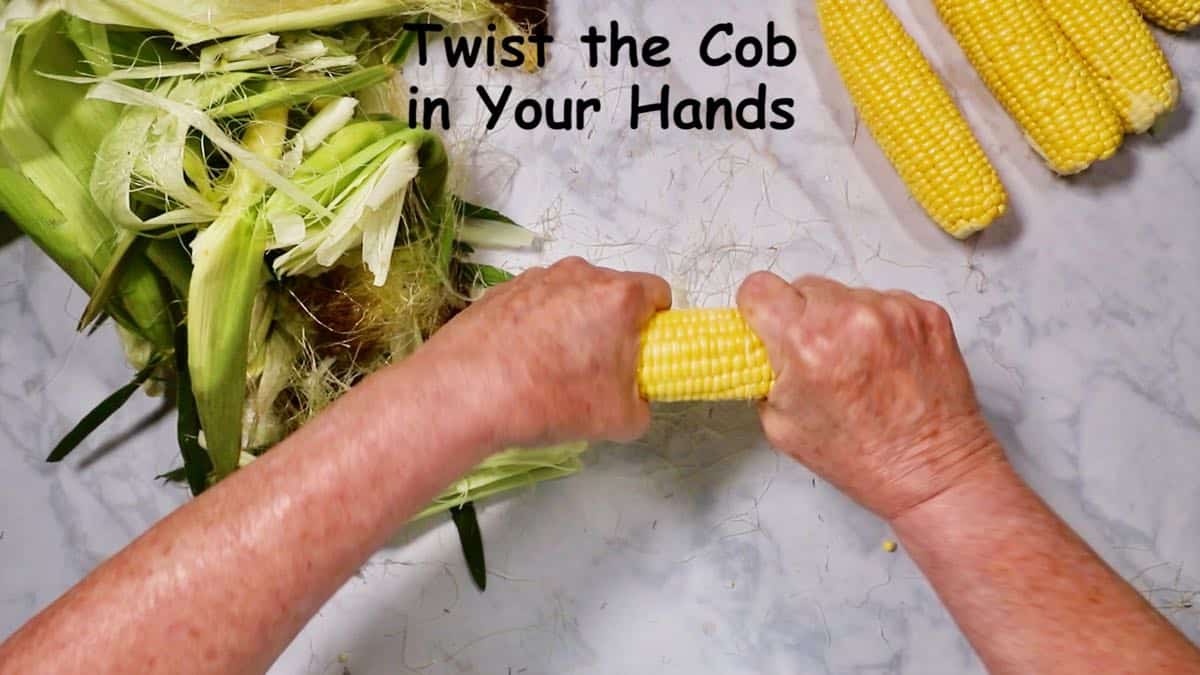 Removing the silk from an ear of corn. 
