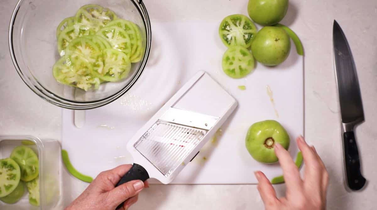 Slicing tomatoes on a mandoline. 