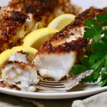 Pecan crusted fish fillets garnished with lemon slices.