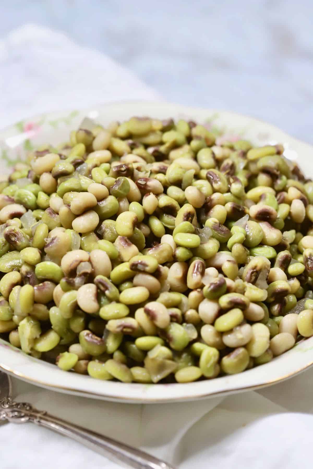 A white bowl full of purple hull peas.