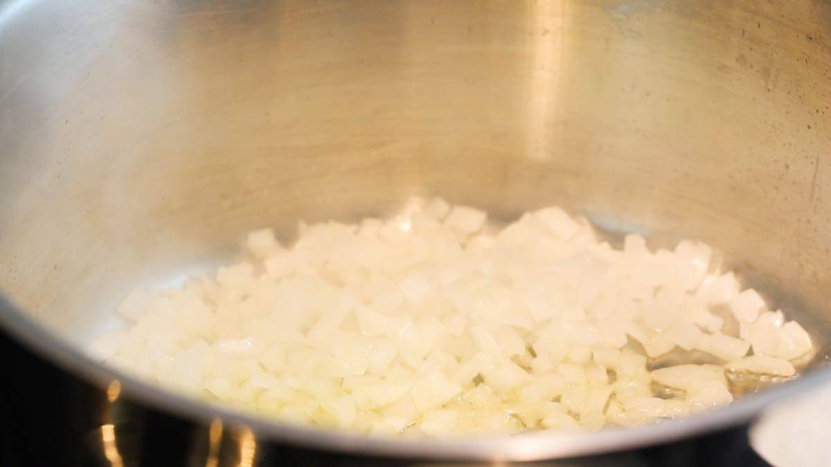 Chopped onion cooking in a saucepan.
