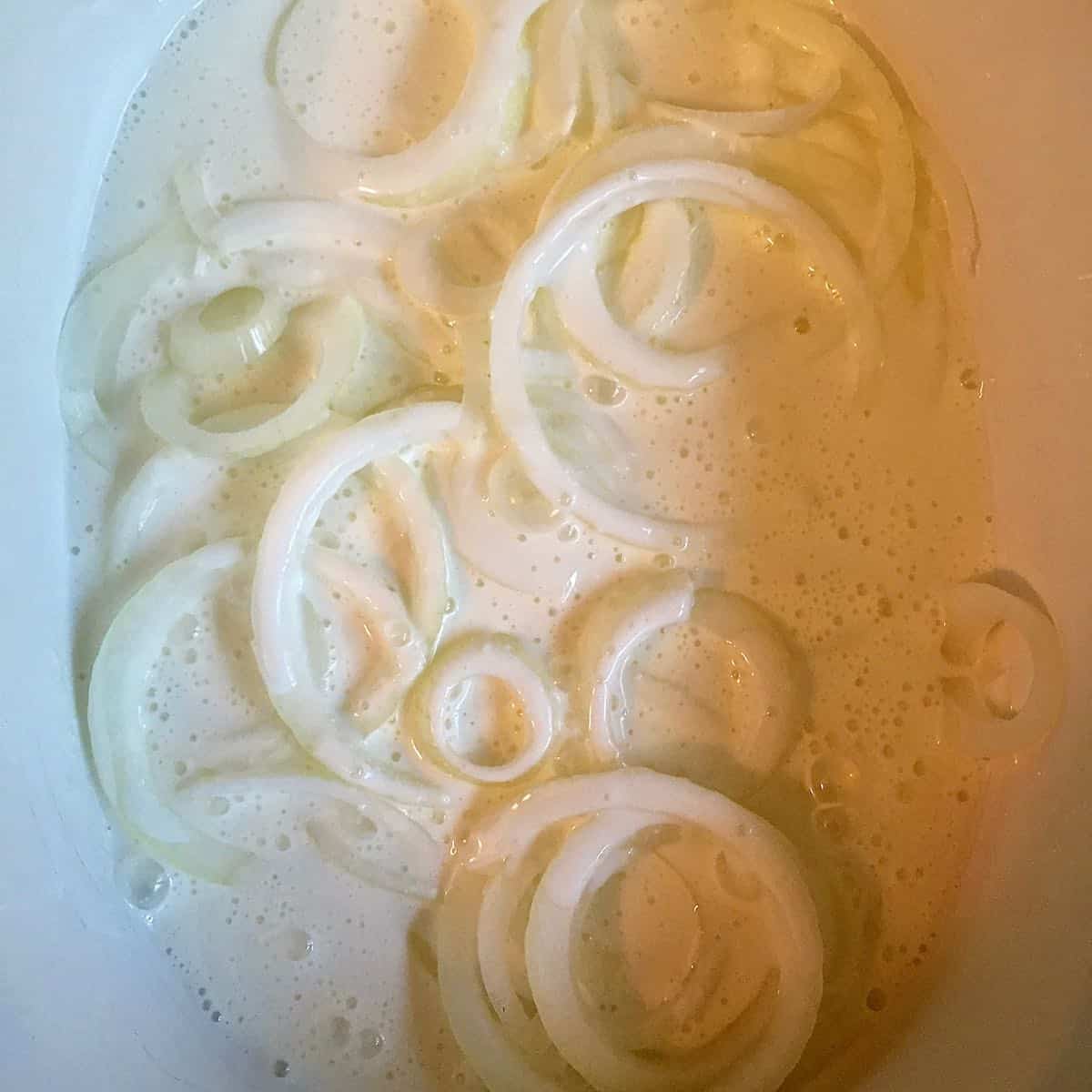 Onion rings soaking in buttermilk.