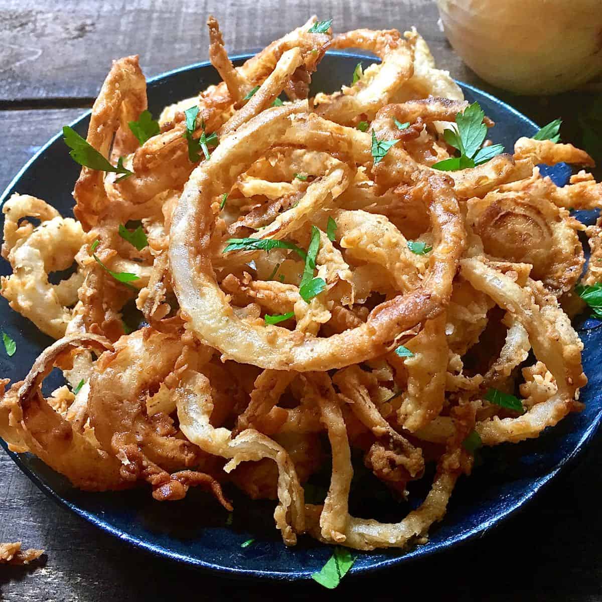 A large serving of fried onion rings.