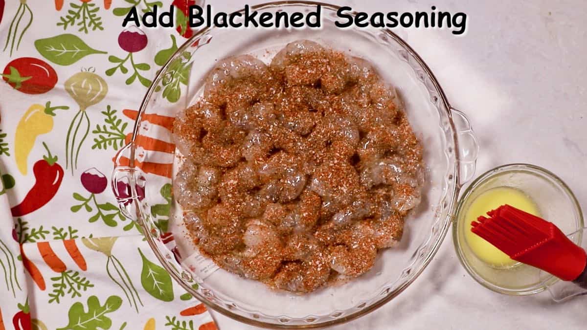 Blackening seasoning over shrimp in a dish.