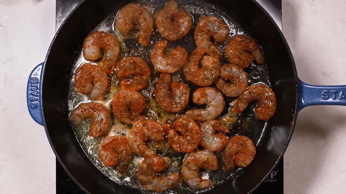 A cast-iron skillet full of shellfish cooking.