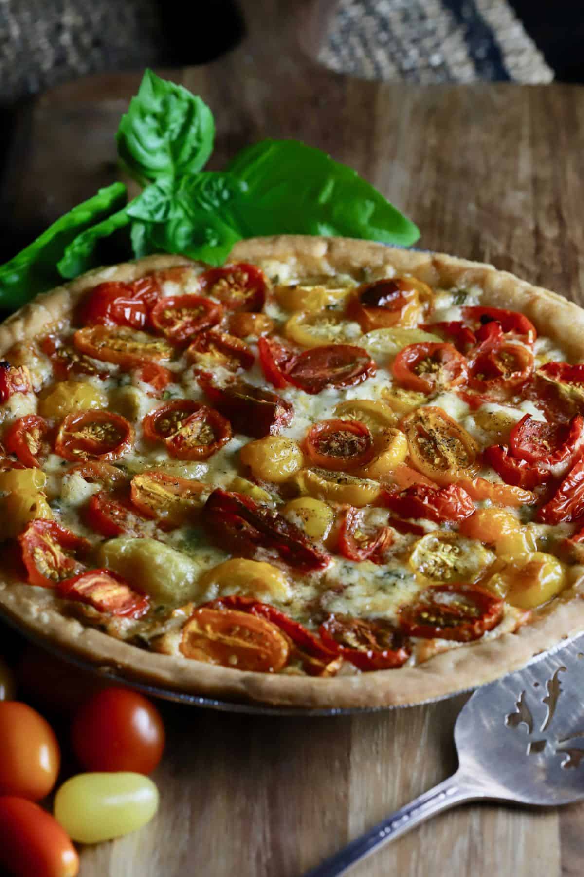 A cherry tomato pie on a cutting board. 