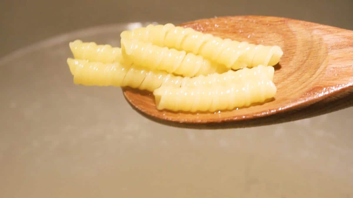 Cooked pasta in a wooden spoon. 