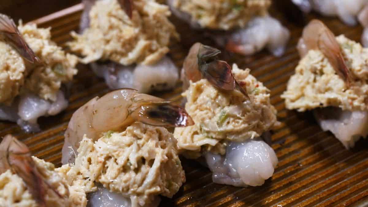 Shrimp stuffed with crabmeat on a baking sheet. 