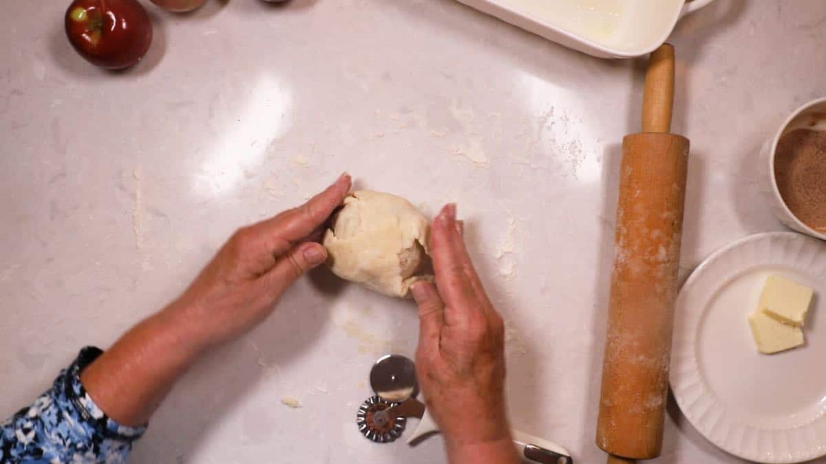 Covering an apple with pastry dough. 