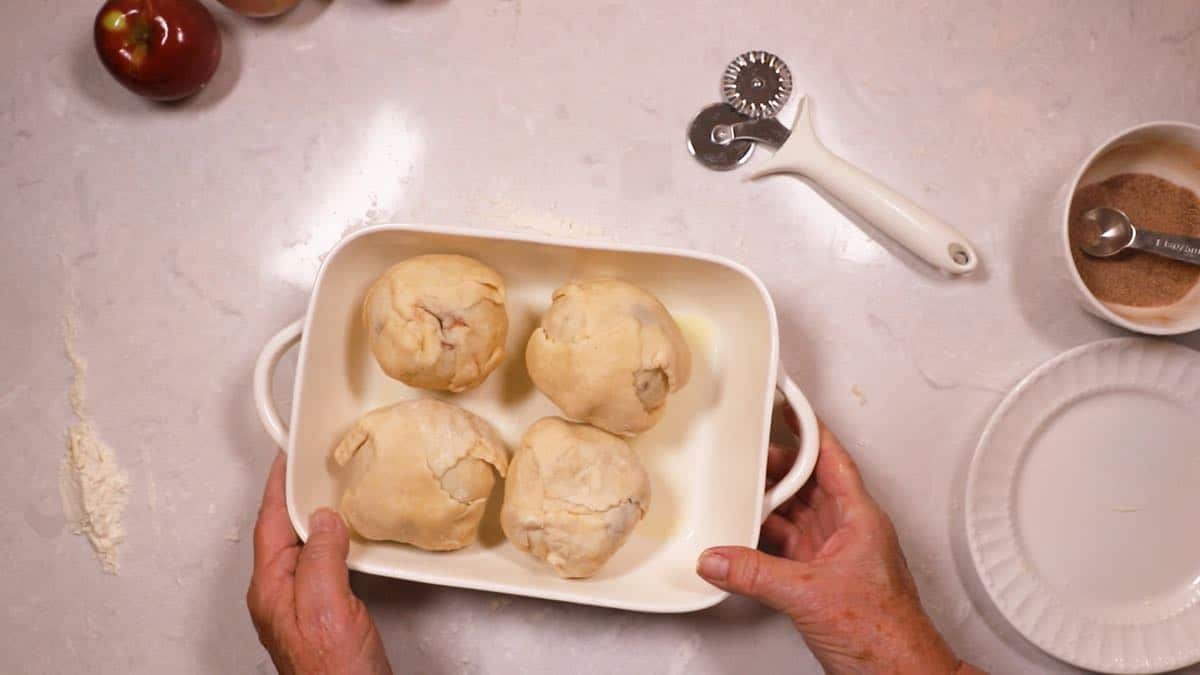 Apples in a baking dish covered with pie dough. 