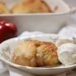 An apple dumpling in a bowl with a scoop of ice cream.