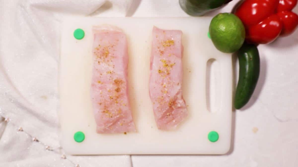 Two grouper fillets on a cutting board. 