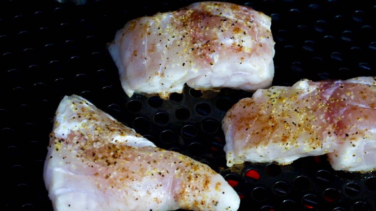Fish fillets cooking on a grill grate. 