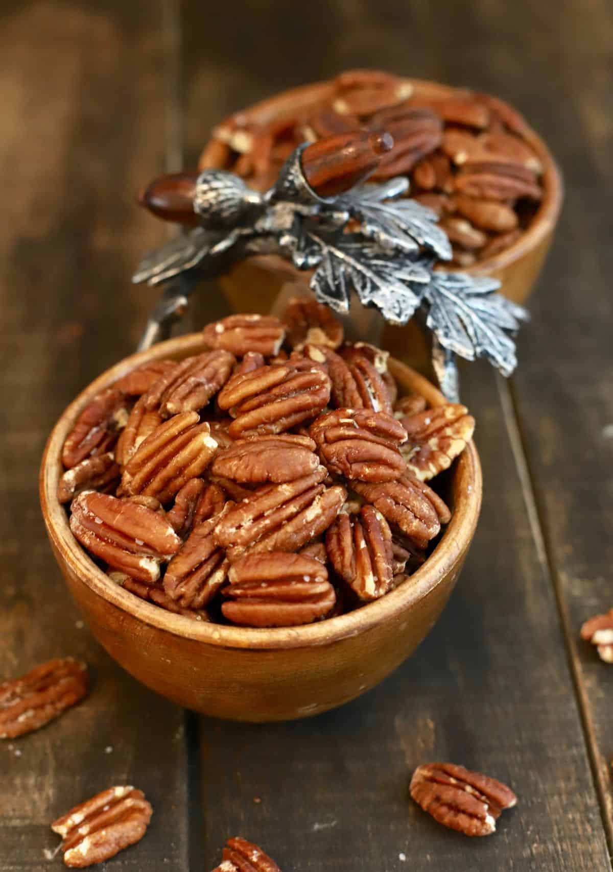 Roasted pecans in small wooden bowls.