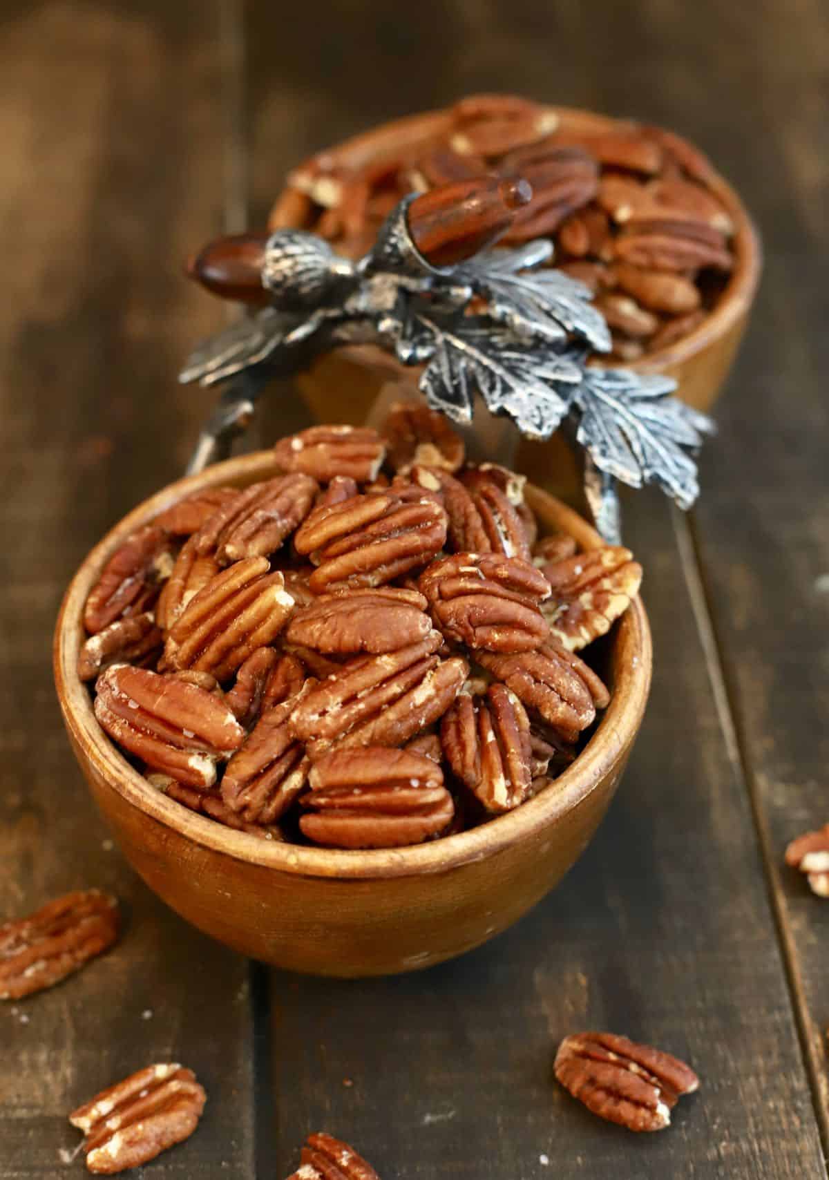 Roasted pecans in small wooden bowls. 