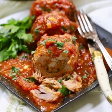 Braciole pork sliced on a plate with marinara sauce.