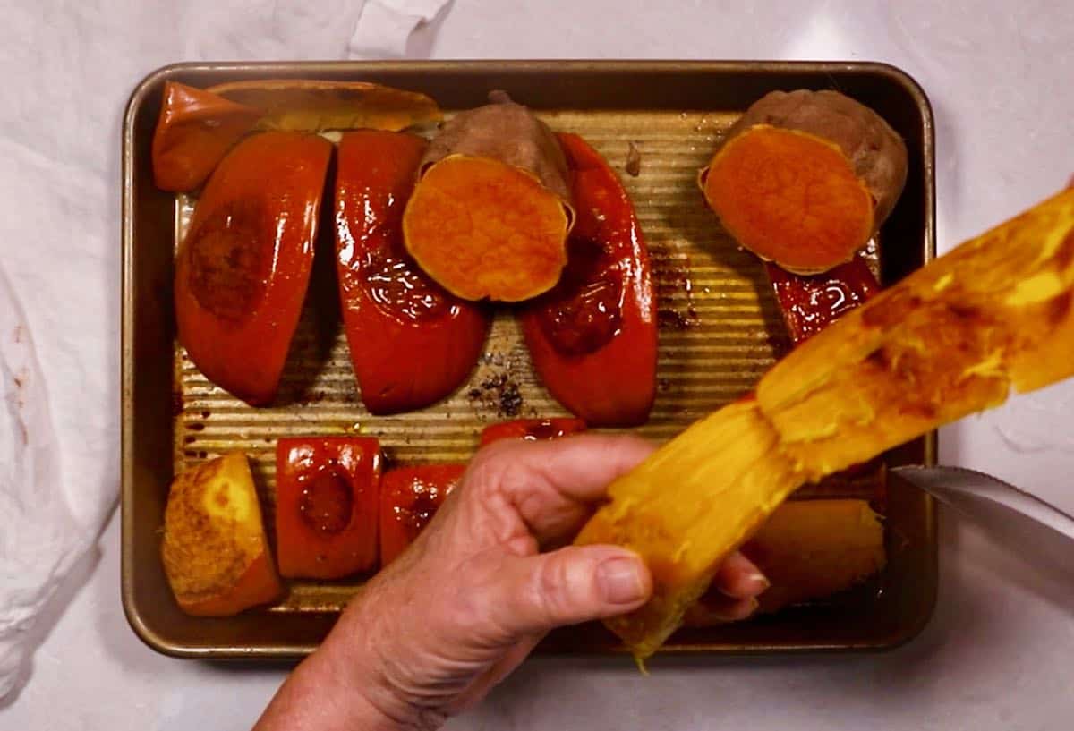 Peeling roasted pumpkin pieces. 