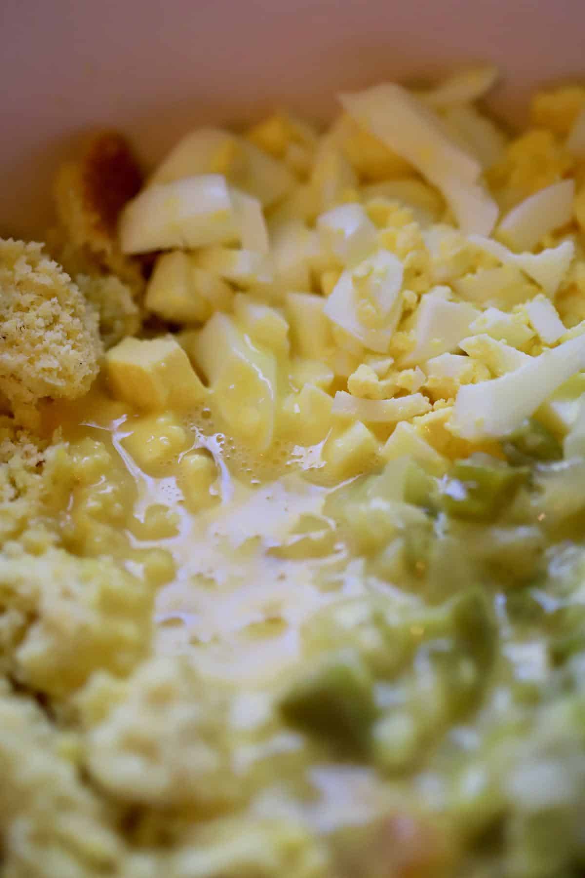 Chopped hard boiled eggs, celery and cornbread in a bowl.