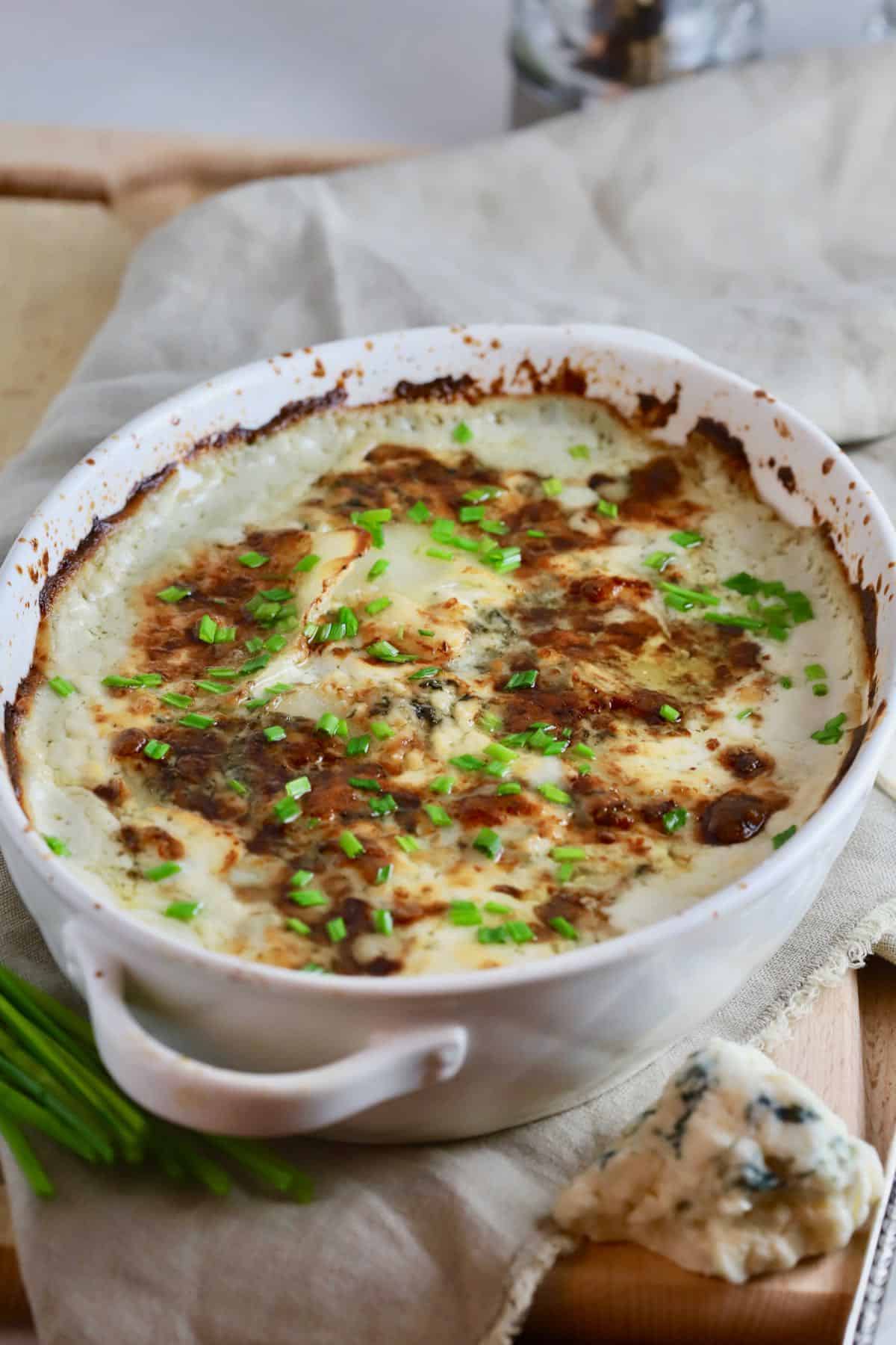Cooked Blue Cheese Au Gratin potatoes in a white baking dish.