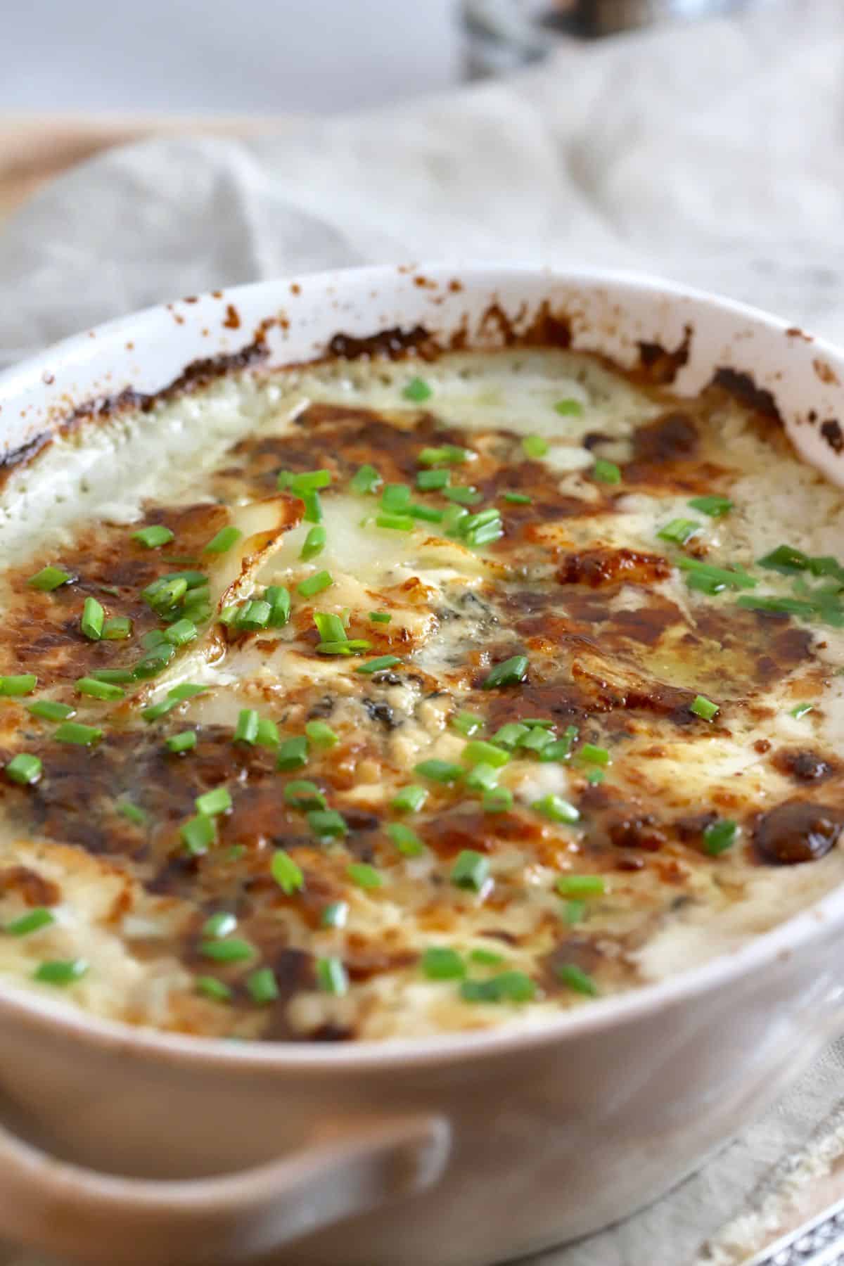 Au Gratin Blue Cheese Potatoes in a white baking dish. 