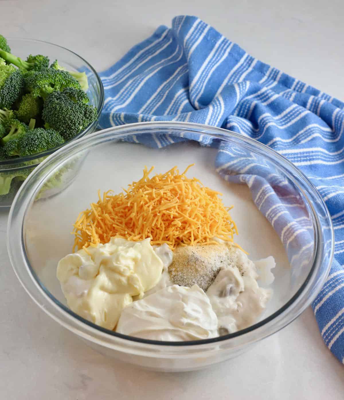A glass bowl with mayonnaise, sour cream and cheese.