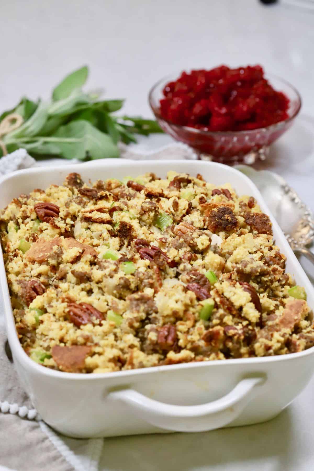 Cornbread Dressing with Sausage and Pecans in a white baking dish.