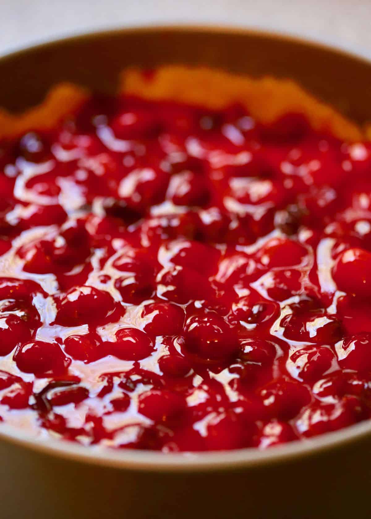 Cooked cranberries poured on top of a cheesecake. 