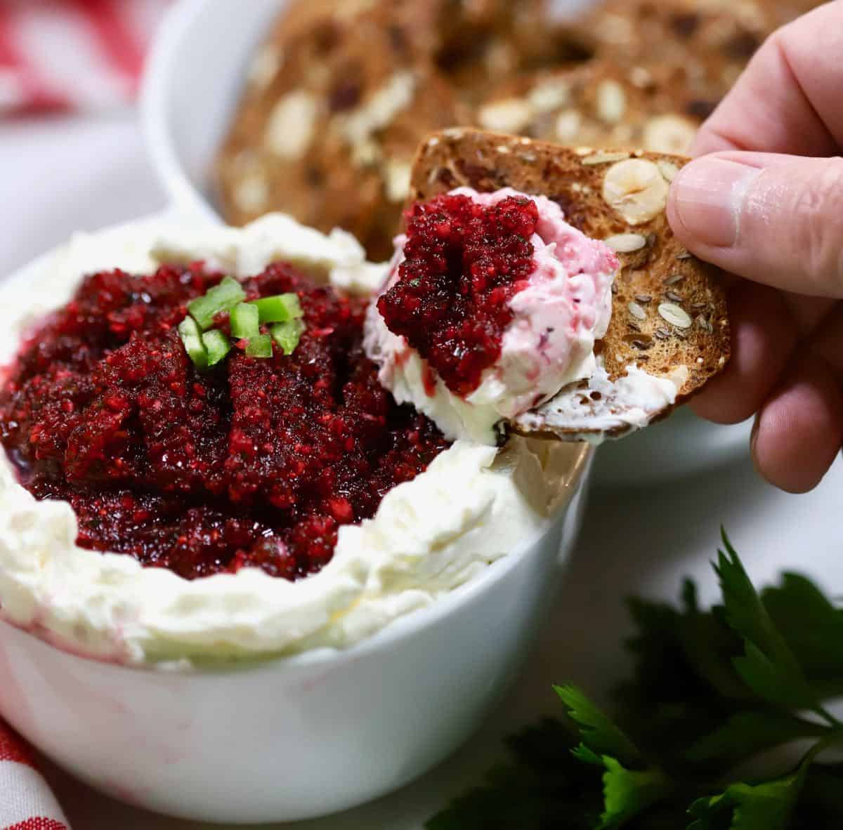 A cracker with a big scoop of cranberry dip. 
