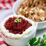A dip dish full of cranberry jalapeno cream cheese dip.
