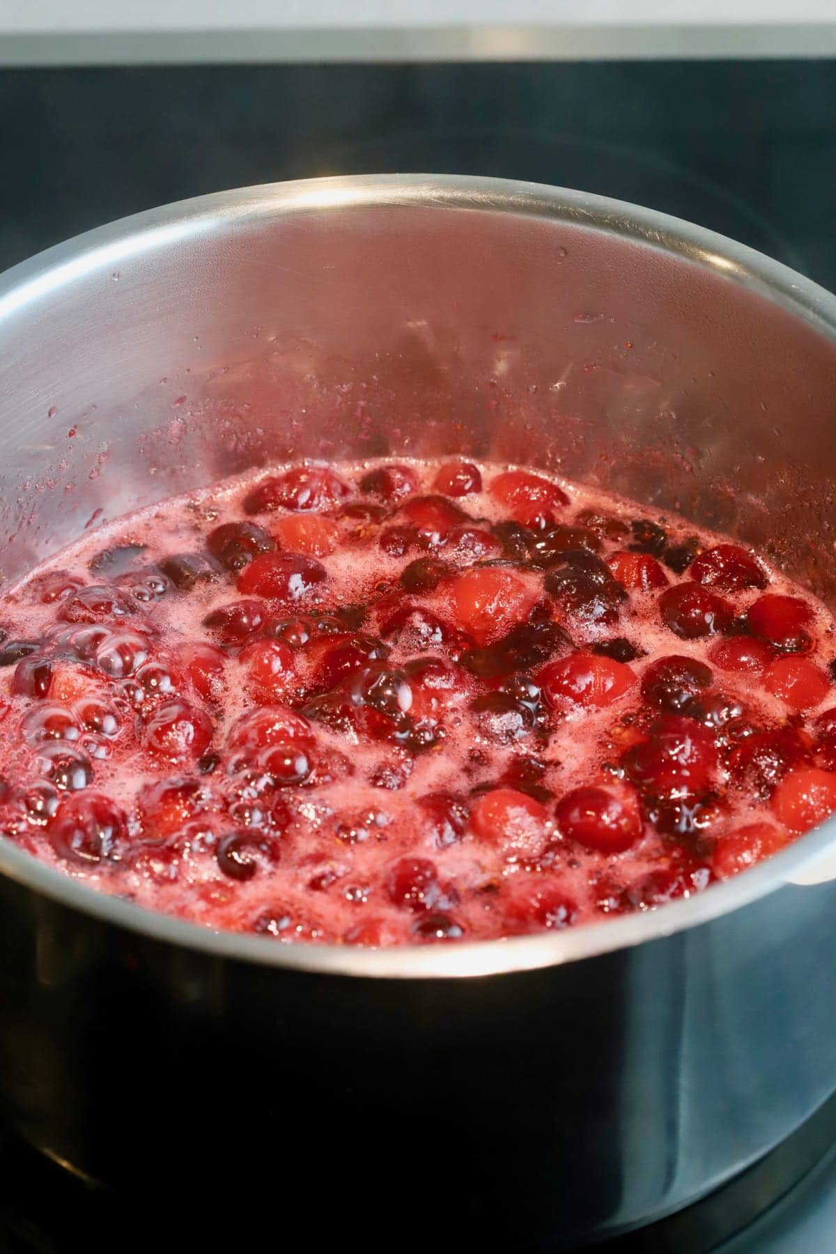 Cranberry sauce cooking in a saucepan.